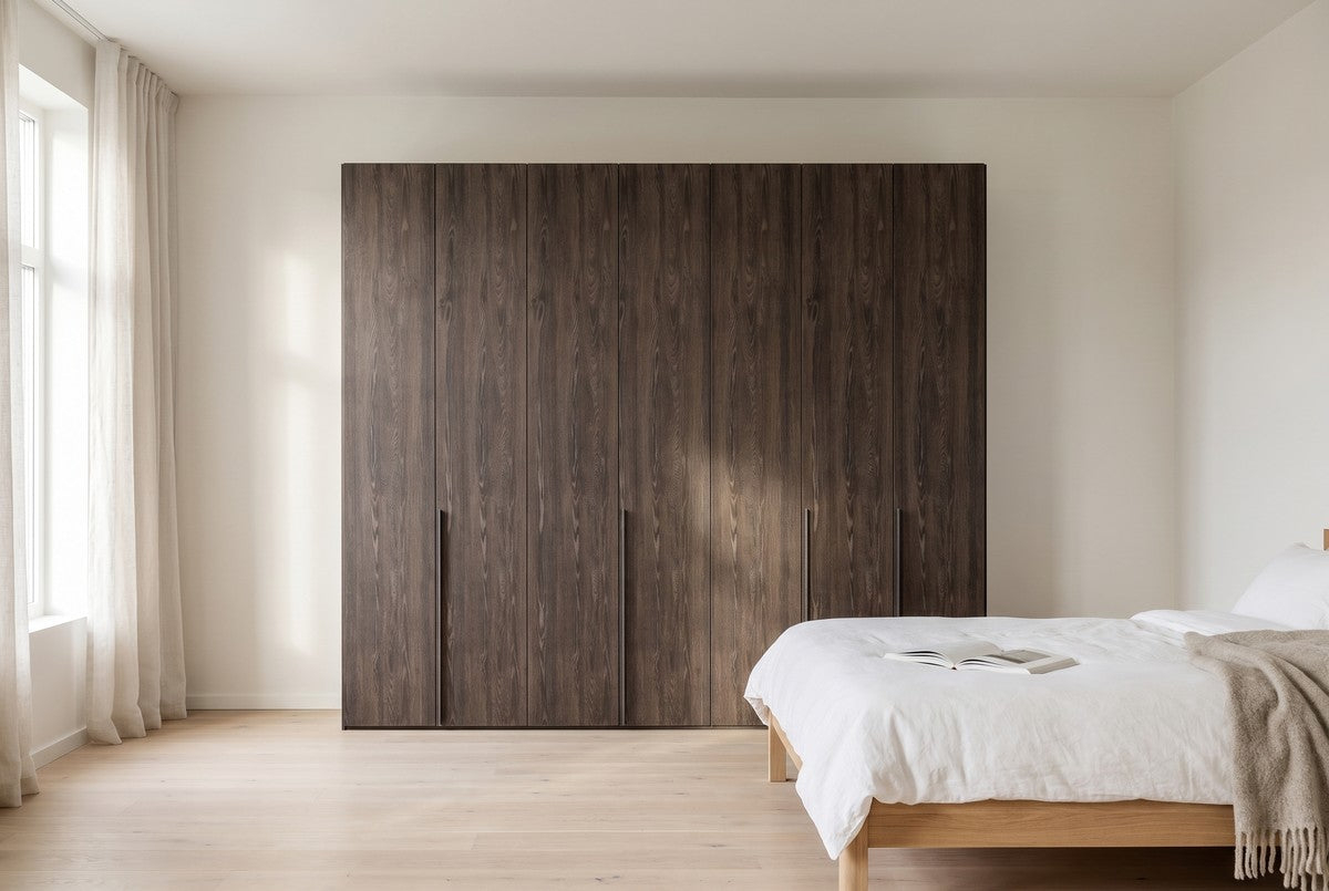 Libeccio-kledingkast in Melamine · Rovere Fiammato in een lichte slaapkamer (AI-sfeerbeeld)