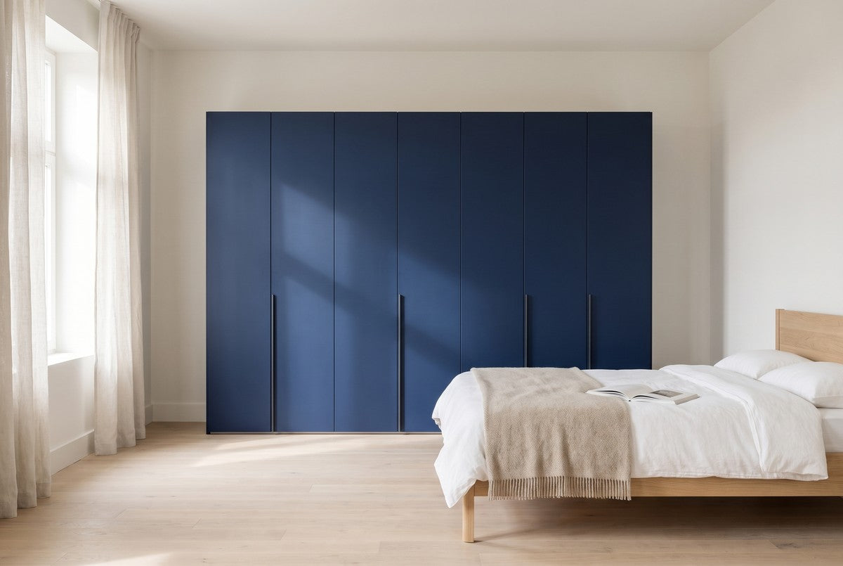 Libeccio-kledingkast in Matlak · Blu Oltremare in een lichte slaapkamer (AI-sfeerbeeld)