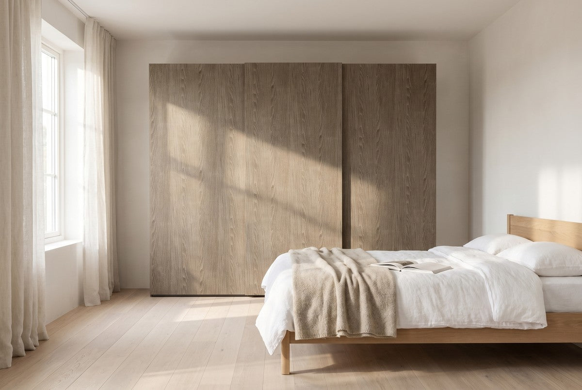 Libeccio-schuifdeurkast in Fineer · Rovere Yuta in een lichte slaapkamer (AI-sfeerbeeld)