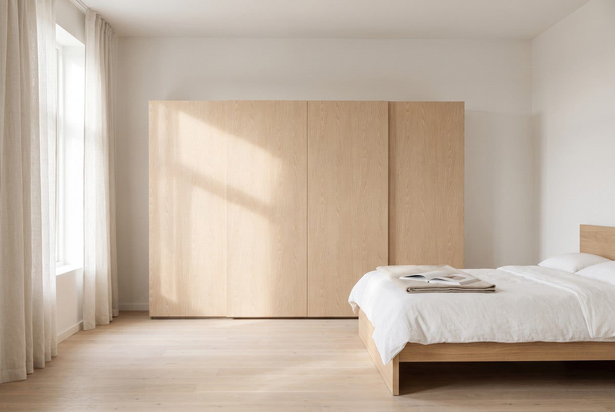 Libeccio-schuifdeurkast in Fineer · Rovere Biondo in een lichte slaapkamer (AI-sfeerbeeld)