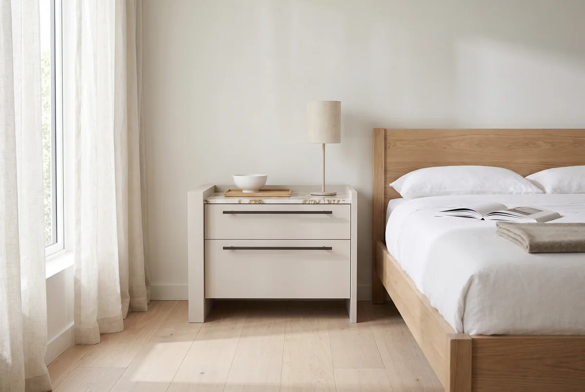 Carry nachtkastje met 2 laden, greep links naast een bed in een lichte, warme slaapkamer (AI-sfeerbeeld)