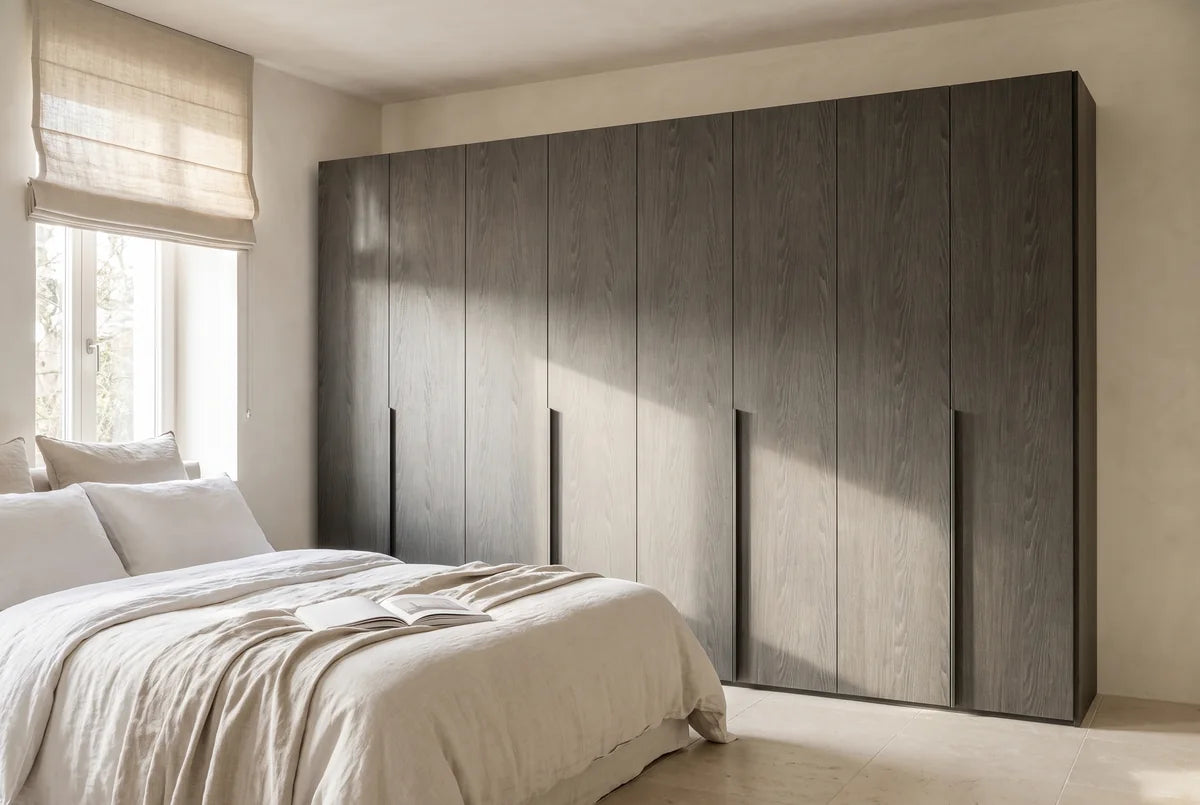 Libeccio-kledingkast in Fineer · Rovere Piombo in een lichte slaapkamer (AI-sfeerbeeld)