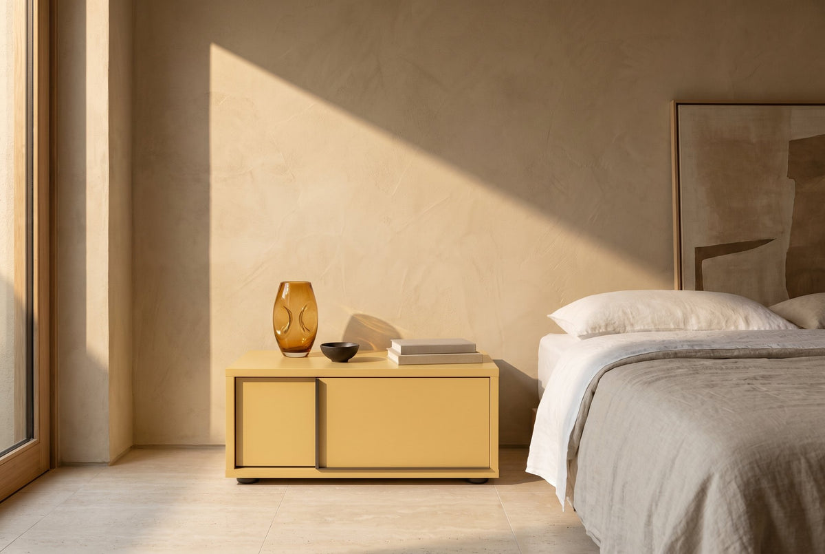 Profile floating nightstand with 1 drawer, strip on the left – Matlak · Ocra – in a bedroom (AI image)